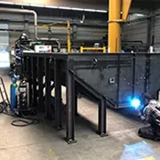 Industrieller Schweißprozess an einer massiven Stahlbaukonstruktion in der Fertigungshalle.